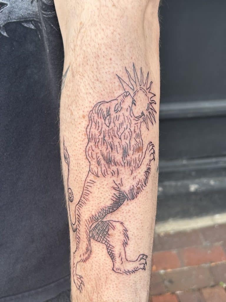 black and grey illustrative tattoo featuring an alchemy lion devouring the sun, done at Mayhem Ink Tattoo in Nashua, New Hampshire.