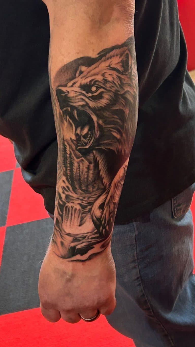 A detailed black and grey realism tattoo of a roaring bear on a forearm custom designed at Mayhem Ink Tattoo in Nashua NH George