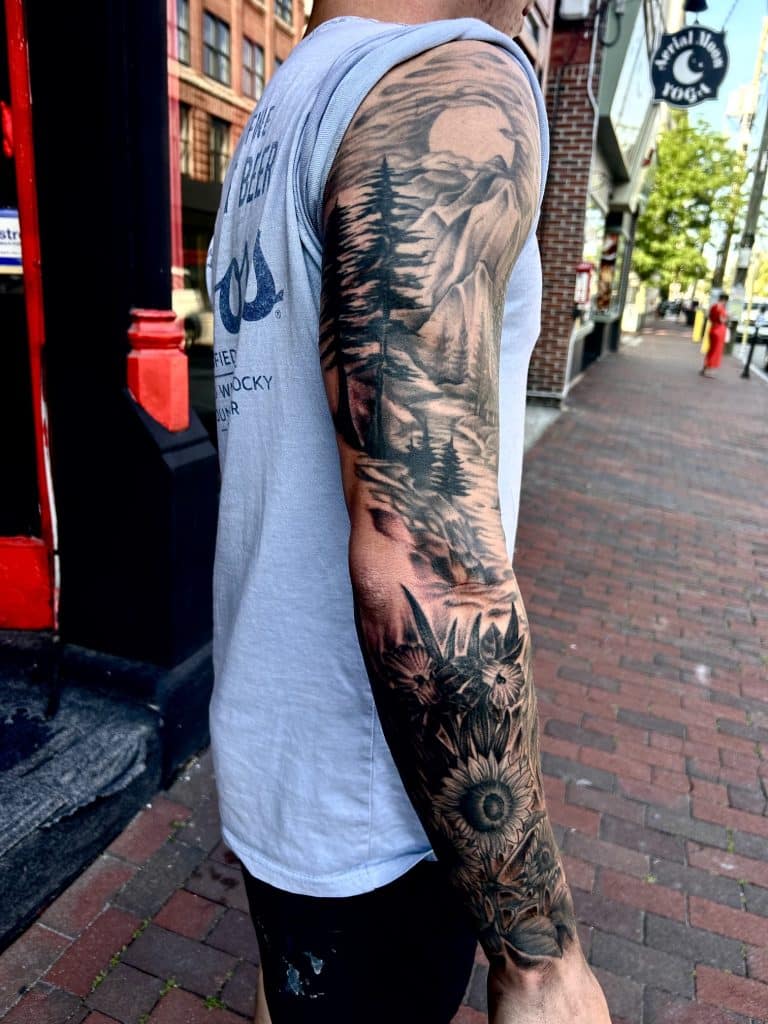 Detailed custom tattoo sleeve featuring vibrant blue accent artwork done by a professional artist at Mayhem Ink Tattoo in Nashua, NH.