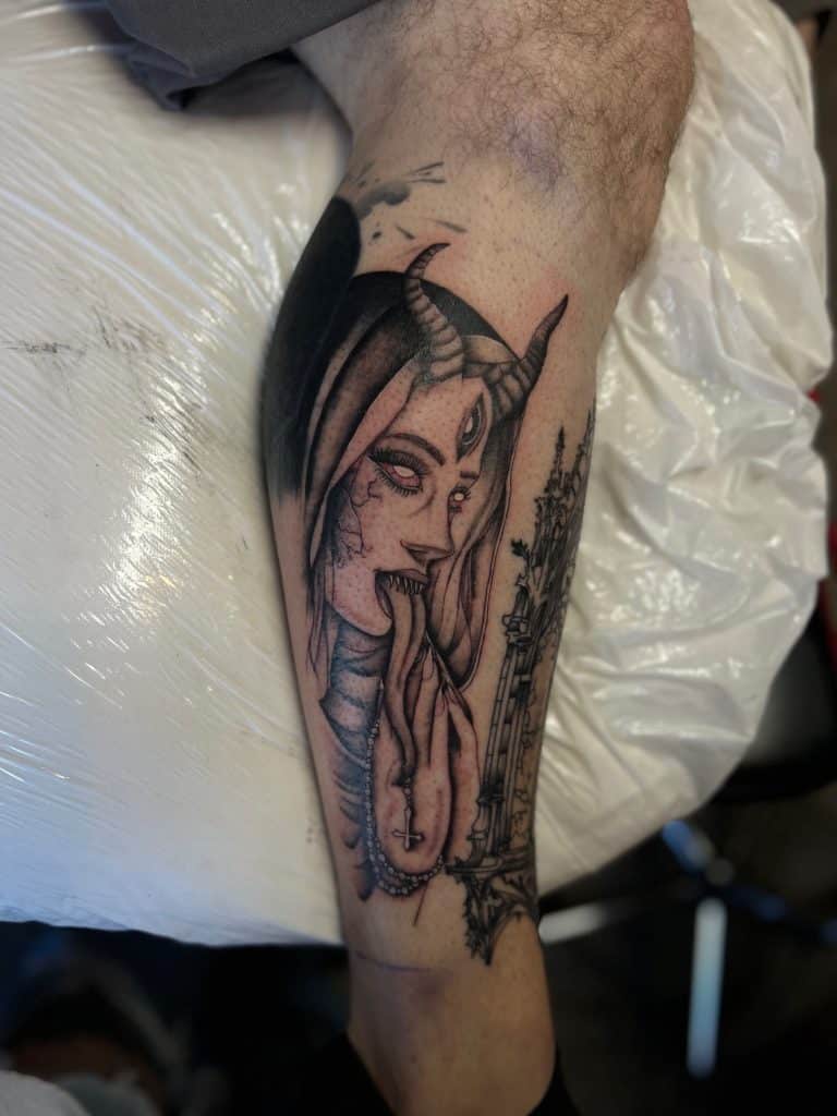 Close-up of a dark, illustrative black and grey portrait tattoo of a demonic woman, done by Briana at Mayhem Ink Tattoo in Nashua, New Hampshire.