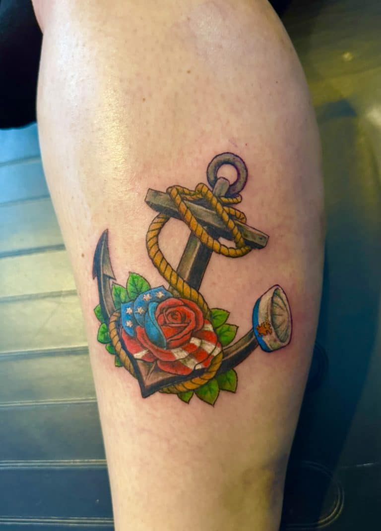 A vibrant color traditional tattoo of an anchor and red roses on an arm or leg, custom designed at Mayhem Ink Tattoo in Nashua, NH.